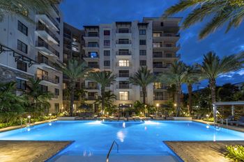 A swimming pool in front of a residential building surrounded by palm trees at Mayla Pompano, Pompano Beach, 33062